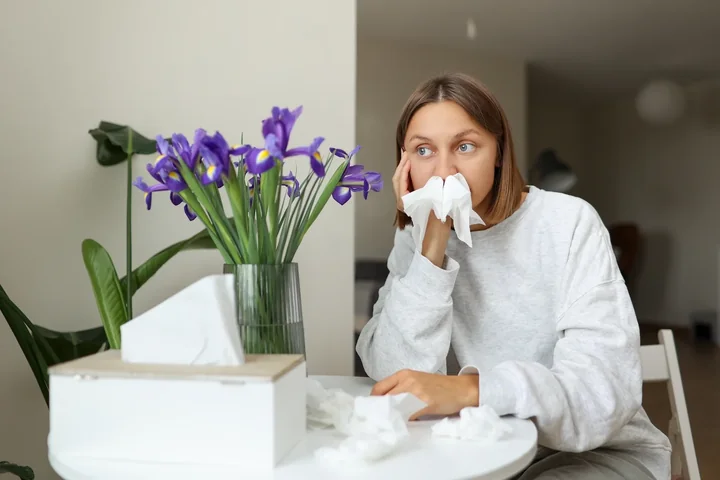Zdjęcie przedstawia kobietę cierpiącą na alergie powodowaną przez pyłki