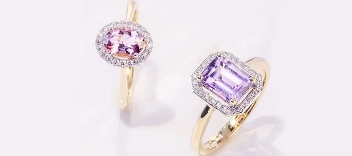 Dwa złote pierścionki z fioletowymi kamieniami szlachetnymi otoczonymi drobnymi diamentami
